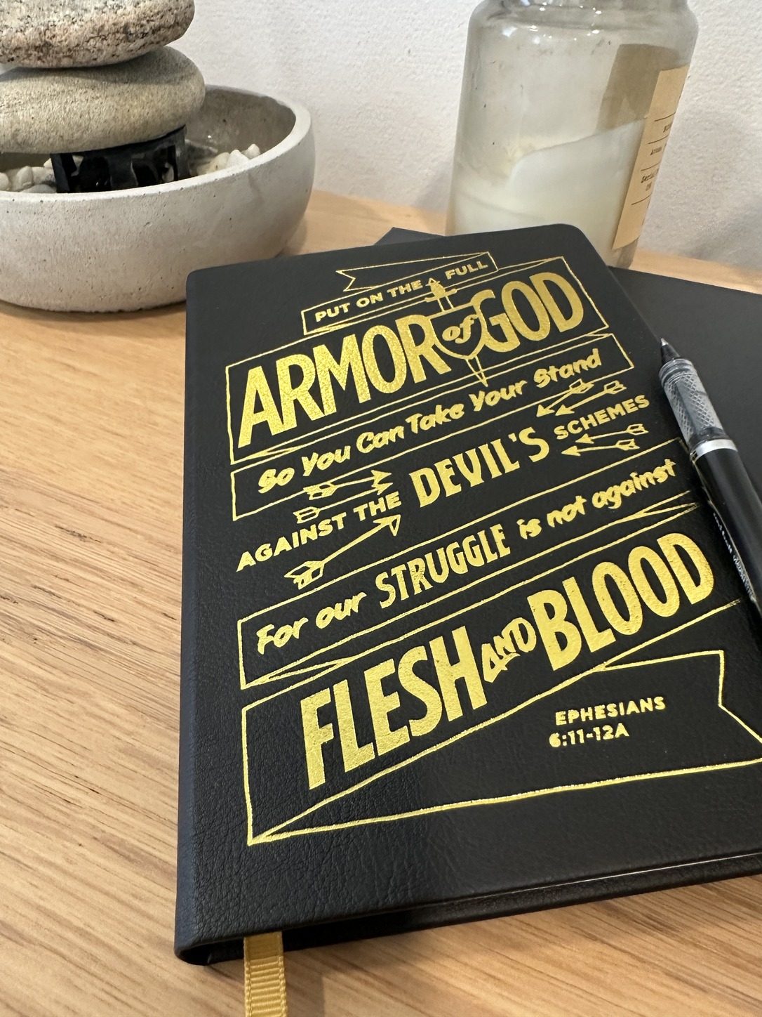 Gospelis Armor of God journal resting on a wooden desk with a pen, ready to write